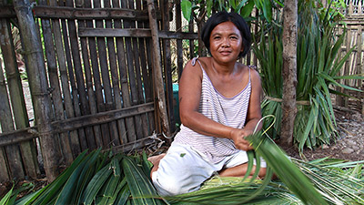 Woman in Philippines makes Shingles out of Nipa Leaves