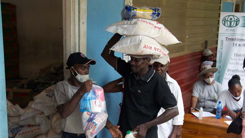 A man carrying food bags on his head after the Haiti earthquake in 2021